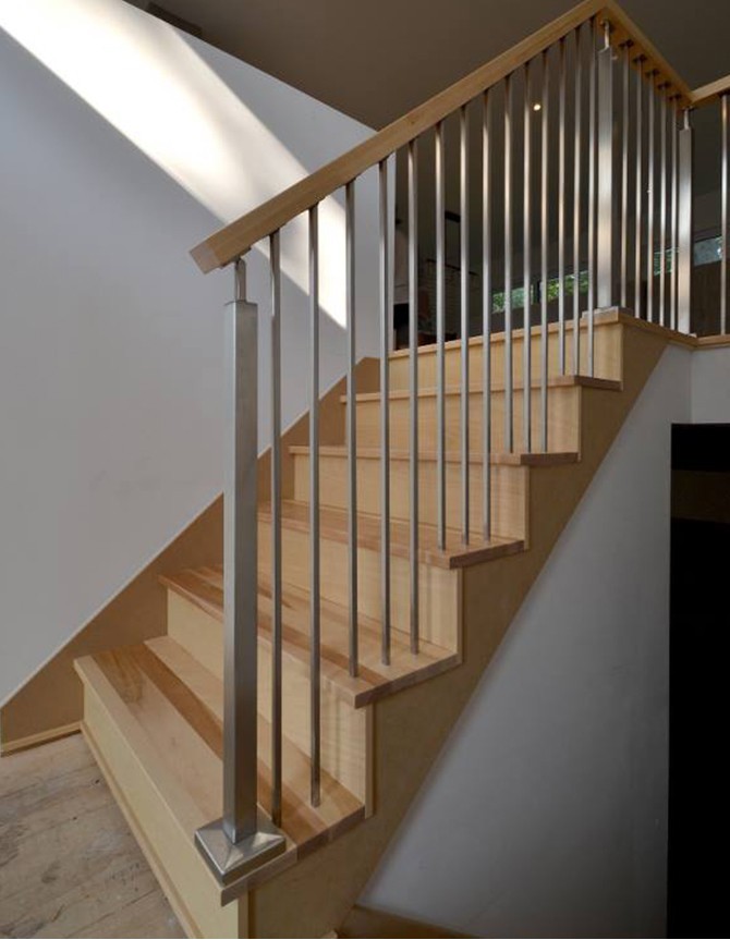 Escalier à demi-tournant avec marches en bois et barreaux en acier inoxydable