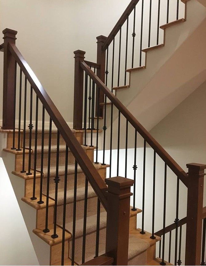 Half-turn wood staircase with forged steel balusters